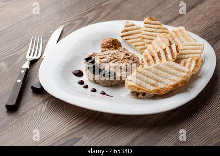 Patata di carne di fegato spalmata con pane bianco alla griglia su sfondo di legno, colazione, primo piano, nessuna gente, fuoco selettivo, pasticcio, pastete. Foto Stock