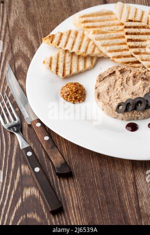 Patata di carne di fegato spalmata con pane bianco alla griglia su sfondo di legno, colazione, primo piano, nessuna gente, fuoco selettivo, pasticcio, pastete. Foto Stock