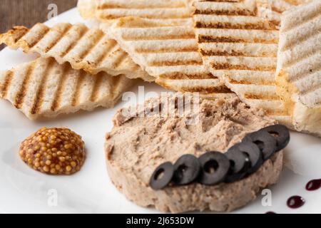 Patata di carne di fegato spalmata con pane bianco alla griglia su sfondo di legno, colazione, primo piano, nessuna gente, fuoco selettivo, pasticcio, pastete. Foto Stock