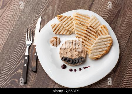 Patata di carne di fegato spalmata con pane bianco alla griglia su sfondo di legno, colazione, primo piano, nessuna gente, fuoco selettivo, pasticcio, pastete. Foto Stock