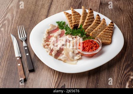 Strutto di maiale tritato crudo con carne, una testa di aglio e pane di segale su un fondo di legno per spazio copia. Un grosso pezzo di grasso fresco. Strutto ucraino, tra Foto Stock