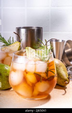 Bevanda alcolica fruttata, dolce pera fredda con rum, liquore, anice e rametto rosmarino, guarnito con pera affettata Foto Stock