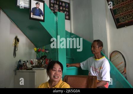 Titin Sunarsih racconta storie sulla carriera di suo figlio nella squadra di vigili del fuoco di Giacarta centrale mentre è seduta davanti al marito all'interno della loro casa a Petojo, Jakarta centrale, Jakarta, Indonesia. Sulistiyo Putranto, suo figlio, passò in servizio come vigile del fuoco. Un dato del 2020 dell'unità open data di Giacarta ha dimostrato che in un periodo compreso tra il 2011 e il 2020, vi sono stati 164 casi di feriti da vigili del fuoco durante lo spegnimento degli incendi nella capitale indonesiana, una media di 16,4 feriti all'anno. Nello stesso periodo, la vita di un vigile del fuoco si è persa. Foto Stock