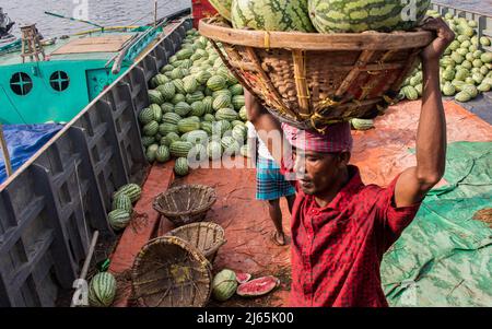 Anguria caricamento dalla barca per la vendita nel Bazar locale. Questa immagine è stata catturata dalla riva del fiume Burigongga il 24 aprile 2022, in D. Foto Stock