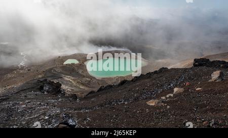 Il vapore vulcanico e le nuvole che si stagliano sui laghi smeraldo, Tongariro Alpine Crossing. Nuova Zelanda. Foto Stock