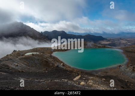 Forte vento che soffia fumi vulcanici sui laghi di smeraldo, Tongariro Alpine Crossing. Nuova Zelanda. Foto Stock