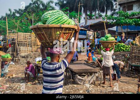 Anguria caricamento dalla barca per la vendita nel Bazar locale. Questa immagine è stata catturata dalla riva del fiume Burigongga il 24 aprile 2022, in D. Foto Stock