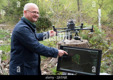 Bonn, Germania. 26th Apr 2022. Il Prof. Dr. Alexander Asteroth, Bonn Rhein Sieg University of Applied Sciences, presenta il suo programma per la registrazione dei danni alla foresta causati dai droni, il primo Ministro Henrik WUEST in una visita al Kottenforst sulla situazione e il futuro della foresta, Credit: dpa/Alamy Live News Foto Stock