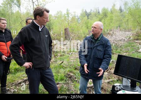 Bonn, Germania. 26th aprile 2022. Da destra: Il Prof. Dr. Alexander Asteroth, Bonn Rhein Sieg University of Applied Sciences, presenta il suo programma per la registrazione dei danni alla foresta causati dai droni, Hendrik WUEST, Wust, CDU, primo Ministro del Nord Reno-Westfalia, primo Ministro Henrik WUEST in una visita al Kottenforst sulla situazione e il futuro della foresta, credito: dpa/Alamy Live News Foto Stock