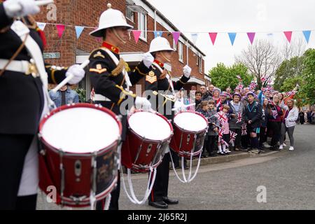 I membri del Royal Marines Band Service sorprendono i residenti di Church Hill a Redditch, vicino a Birmingham, mentre suonano un medley di melodie per riconoscere alla comunità di aver iniziato a celebrare il Giubileo del platino della Regina Elisabetta questo giugno, Con oltre 40 grandi pranzi giubilari progettati per riunire i vicini sulle strade locali. Data foto: Giovedì 28 aprile 2022. Foto Stock