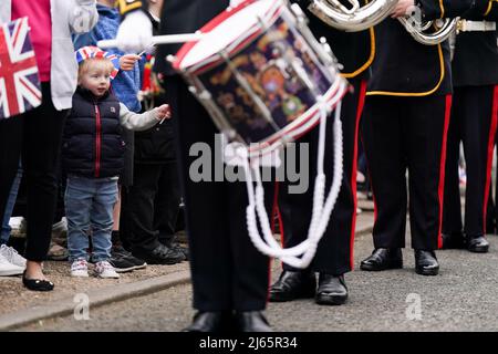 Un giovane ragazzo guarda i membri del Royal Marines Band Service giocare per i residenti di Church Hill a Redditch, vicino a Birmingham, per riconoscere la comunità che si è intensamente impegnata a celebrare il Giubileo del platino della Regina Elisabetta questo giugno, con oltre 40 grandi pranzi giubilari previsti per riunire i vicini sulle strade locali. Data foto: Giovedì 28 aprile 2022. Foto Stock