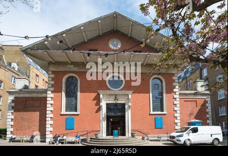 Persone sedute su panchine, socializzanti e rilassanti nel giardino della Chiesa di San Paolo, Covent Garden, in una soleggiata primavera. Londra, Inghilterra, Regno Unito. Foto Stock