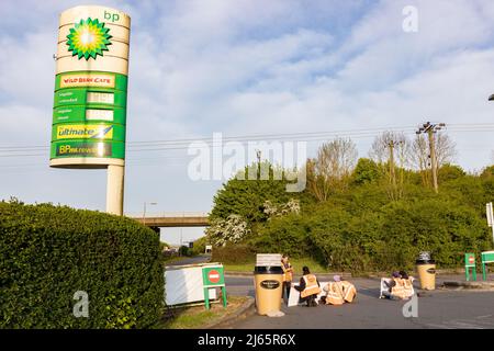 Kent, Regno Unito. 28 aprile 2022 i manifestanti di Just Stop Oil hanno bloccato il garage BP presso Clacket Lane Services il M25. Essi chiedono al governo di porre fine all’estrazione di nuovi combustibili fossili e alla perforazione di gas e petrolio, esortandoli invece a investire in energie rinnovabili. I manifestanti smash il vetro su pompe a benzina e graffiti sulla parte anteriore, infine incollandosi alle pompe credito: Denise Laura Baker/Alamy Live News Credit: Denise Laura Baker/Alamy Live News Foto Stock