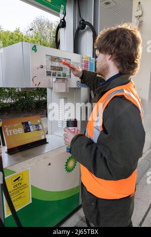 Kent, Regno Unito. 28 aprile 2022 i manifestanti di Just Stop Oil hanno bloccato il garage BP presso Clacket Lane Services il M25. Essi chiedono al governo di porre fine all’estrazione di nuovi combustibili fossili e alla perforazione di gas e petrolio, esortandoli invece a investire in energie rinnovabili. I manifestanti smash il vetro su pompe a benzina e graffiti sulla parte anteriore, infine incollandosi alle pompe credito: Denise Laura Baker/Alamy Live News Credit: Denise Laura Baker/Alamy Live News Foto Stock