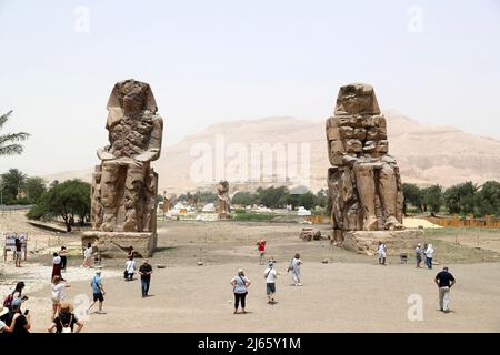 Cairo, Egitto. 26th Apr 2022. I turisti visitano i Colossi di Memnon a Luxor, Egitto, 26 aprile 2022. Luxor, una capitale dell'antico Egitto superiore conosciuta come Tebe, è ora una destinazione turistica famosa per gli edifici storici del tempio e altre reliquie. Credit: Sui Xiankai/Xinhua/Alamy Live News Foto Stock