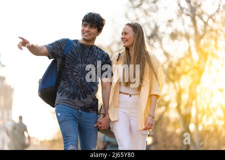 Giovane coppia eterosessuale che cammina in un parco e parla Foto Stock