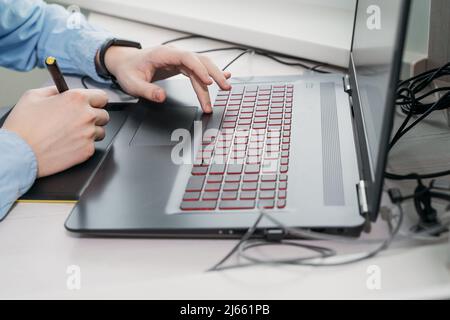 Designer grafico che utilizza tablet e computer digitali in ufficio. Mani in primo piano Foto Stock