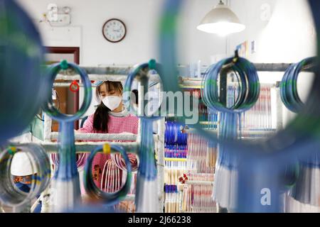 SUQIAN, CINA - 28 APRILE 2022 - Un lavoratore effettua ordini in un laboratorio di un racket di alta qualità in fibra di carbonio di badminton a Suqian, Jiangsu della Cina orientale Foto Stock