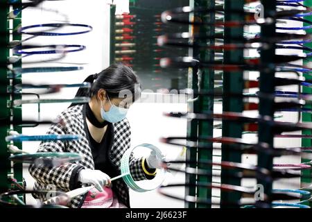 SUQIAN, CINA - 28 APRILE 2022 - Un lavoratore effettua ordini in un laboratorio di un racket di alta qualità in fibra di carbonio di badminton a Suqian, Jiangsu della Cina orientale Foto Stock