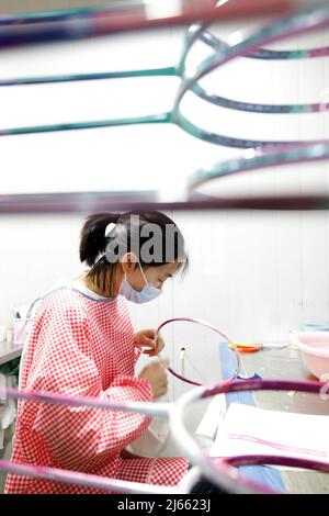 SUQIAN, CINA - 28 APRILE 2022 - Un lavoratore effettua ordini in un laboratorio di un racket di alta qualità in fibra di carbonio di badminton a Suqian, Jiangsu della Cina orientale Foto Stock