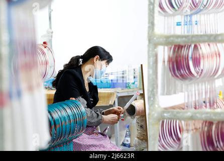 SUQIAN, CINA - 28 APRILE 2022 - Un lavoratore effettua ordini in un laboratorio di un racket di alta qualità in fibra di carbonio di badminton a Suqian, Jiangsu della Cina orientale Foto Stock