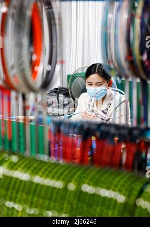 SUQIAN, CINA - 28 APRILE 2022 - Un lavoratore effettua ordini in un laboratorio di un racket di alta qualità in fibra di carbonio di badminton a Suqian, Jiangsu della Cina orientale Foto Stock