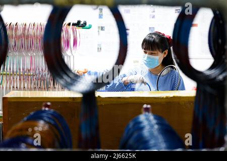 SUQIAN, CINA - 28 APRILE 2022 - Un lavoratore effettua ordini in un laboratorio di un racket di alta qualità in fibra di carbonio di badminton a Suqian, Jiangsu della Cina orientale Foto Stock