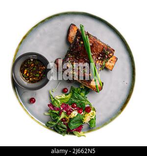 Porzione isolata di costolette di vitello arrosto con salsa Foto Stock