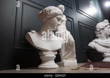 Copia in gesso dell'antica statua Apollo, Afrodite e Venere su sfondo scuro. Volto di scultura in gesso Foto Stock