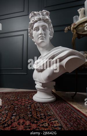 Dio Apollo busto scultura. Antico dio greco del Sole e Poesia copia in pietra di una statua di marmo isolata in nero Foto Stock