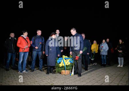 Slavutych, Ucraina. 26th Apr 2022. Persone viste con fiori al Monumento agli Eroi defunti di Chernobyl. Il 36th anniversario della catastrofe della centrale nucleare di Cernobyl si è verificato il 26th 1986 aprile (alle 01.23.40), è stato commemorato con una cerimonia pubblica a Slavutych (Ucraina), una città satellite costruita dopo la catastrofe, che ospita principalmente i lavoratori della centrale. Credit: SOPA Images Limited/Alamy Live News Foto Stock