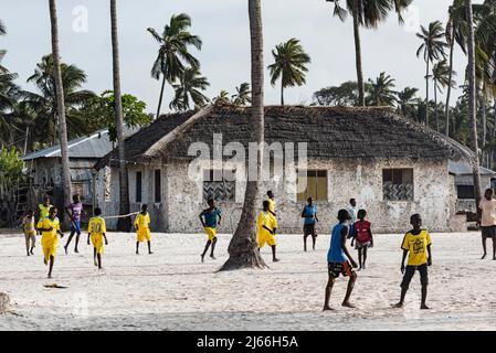 Jungen spielen Fussball im Dorf Jambiani, gelbe Trikots, Unguja, Ostkueste, Sansibar, Tansania Foto Stock