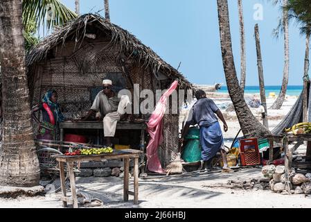 Huette aus Schilf am Strand, Laden, Mann und Frau im Gespraech, Nungwi, Nordkueste, Unguja, Sansibar, Tansania Foto Stock