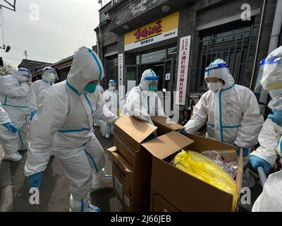 Pechino, Cina. 24th Apr 2022. I lavoratori della Comunità trasportano forniture mediche nel distretto di Xicheng di Pechino, capitale della Cina, 24 aprile 2022. Durante l'ultima rinascita delle infezioni COVID-19 a Pechino, persone di diversi tipi di vita si sono unite alla lotta contro il coronavirus, lavorando contro il tempo per offrire un sostegno sostanzioso. Credit: Jiang Zhen/Xinhua/Alamy Live News Foto Stock