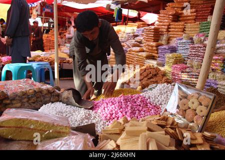 Afghanistan, Afghanistan. 27th Apr 2022. Un venditore organizza il cibo in una stalla davanti all'Eid al-Fir nella provincia di Kunduz, Afghanistan, 27 aprile 2022. EID al-Fitr, il festival di rompere il digiuno che segna la fine del mese santo islamico del Ramadan, è celebrato dai musulmani in tutto il mondo. Credit: Aimal Kakr/Xinhua/Alamy Live News Foto Stock