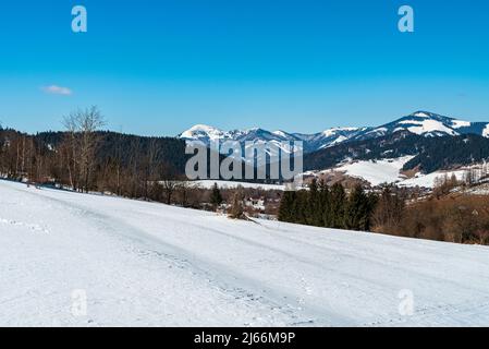 Velka Fatra montagne tra Rakytov e colline Smrekovica da sentiero escursionistico sopra Liptovska Luzna villaggio in Slovacchia durante la giornata invernale con chiaro sk Foto Stock