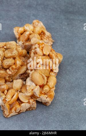 La fragola di arachidi, un vecchio favorito dolce della scuola, tagliato in piccole barre su superficie di tipo rustico con spazio di copia Foto Stock