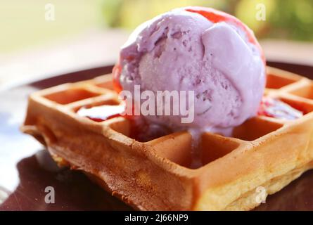 Primo piano di waffle appena sfornati fatti in casa con gelato al mirtillo Foto Stock