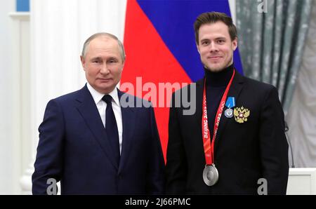 Mosca, Russia. 26 aprile 2022. Il presidente russo Vladimir Putin si presenta con la medaglia olimpica Nikita Katsalapov durante una cerimonia che premia medaglie di stato agli atleti del Comitato olimpico russo al Cremlino il 26 aprile 2022 a Mosca, Russia. Katsalapov ha vinto una medaglia d'oro in squadra alle Olimpiadi invernali di Pechino del 2022. Credit: Mikhael Klimentyev/Kremlin Pool/Alamy Live News Foto Stock