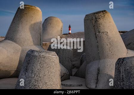Leuchtturm a Hörnum auf der Insel Sylt, Nordfriesische Inseln (Germania). Tetrapoden zur Bevestigung des Strandes. Foto Stock