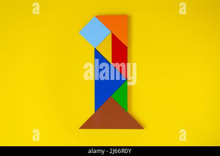 Colorato numero 1 fatto con tangram giocattolo, tangram colorato numero sette isolato su sfondo giallo, vista laterale del settimo numerico, idea di gioco per bambini Foto Stock