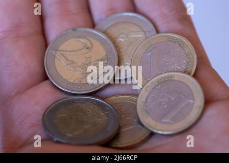 Monete in mano maschile, vista laterale ravvicinata, concetto di risparmio di denaro, monete metalliche a portata di mano Foto Stock