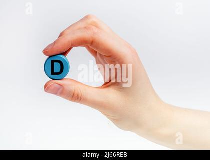 Mano donna con modello di vitamina D. Assistenza sanitaria e sistema immunitario normale funzionamento concetto. Nutriente, integratore alimentare. Foto di alta qualità Foto Stock