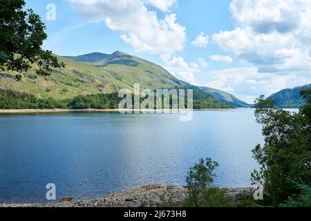 Vista attraverso Thilrmere verso Helvellyn nel Lake District inglese, Cumbria, Regno Unito in una giornata luminosa e soleggiata con le nuvole bianche e fluide nel cielo. Foto Stock