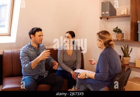 Terapia di coppia. Coppia seria piacevole che visita uno psicologo ed avere una sessione psicologica mentre si occupa insieme dei problemi nei rapporti Foto Stock