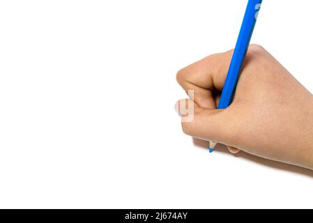 La mano della ragazza che scrive con una matita blu su un foglio bianco Foto Stock