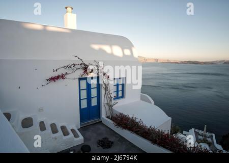 Oia, Grecia - 11 maggio 2021 : un bellissimo edificio residenziale imbiancato di bianco che si affaccia sul Mar Egeo in Oia Santorini Foto Stock