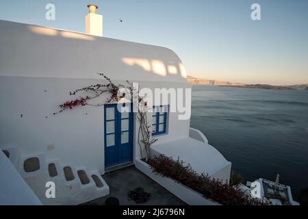 Oia, Grecia - 11 maggio 2021 : un bellissimo edificio residenziale imbiancato di bianco che si affaccia sul Mar Egeo in Oia Santorini Foto Stock