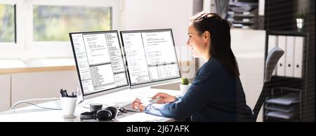 Coder Engineer che utilizza più monitor alla scrivania Foto Stock