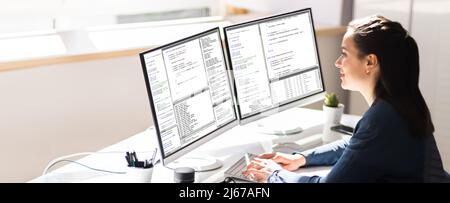 Coder Engineer che utilizza più monitor alla scrivania Foto Stock